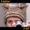 tessercat: Me taking a photo of myself wearing a cat in a mirror (a knitter is me)
