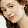 eva_wilson: Emmy Rossum in a white top, smiling (Eva softly smiling)