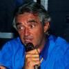 augusto_corlioni: A picture of Flavio Briatore in his forties, holding a microphone (Default)