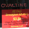 heuradys: neon sign: Ovaltine, below that a sign: All Day Breakfast Special $3.50 (breakfast special)