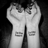 milkymoon: A woman's hands, tattooed with 'in the heart' on one wrist and 'in the head' on the other. (In the heart.)