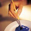ext_3673: Hand holding a paintbrush mixing paint (art)