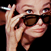 this_girl_is: Audrey Hepburn with a cigarette, looking over sunglasses (Default)