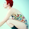 tree: a red haired woman side on showing butterfly tattoos down her torso ([else] embodiment)