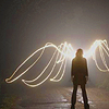 syntheid: shadowed figure standing on a road with wings made of light (i run from what's behind me)