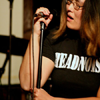 fatoudust: Lisa on stage with microphone, wearing Headnoise t-shirt (mic)