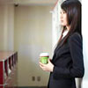 advisor: A woman resting against a wall with a takeout cup of tea. (tea)
