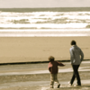 sara: A parent and child walking on the beach (walk on the beach)