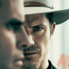 esteefee: Raylan Givens facing forward, staring grimly at Boyd in profile. (justified)