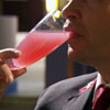 pinesandmaples: Concierge Tony drinks a bright pink cocktail from a champaign flute. (Hotel Babylon: Tony sips)