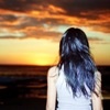 theresistance: A person with long blue-black hair seen from behind as they watch the setting sun (Little Seahorse - Distance)