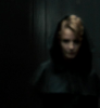 fish_echo: Fuzzy image of Mary (new Sherlock Holmes movie) looking vaguely mysterious in a dark coat against a dark background (Fandom-SHnew-fuzzy mary in dark coat)