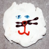 red_trillium: cat-like face made out of white roll-out frosting with blue eyes (Frosting Face)