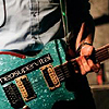 heuradys: closeup of a sparkly blue guitar with 'neosupervital' sticker on it (nsv guitar)