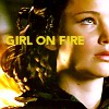 next_to_normal: Katniss in her flame costume; text: girl on fire (girl on fire)