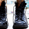 grey_gazania: feet in a pair of unlaced heavy black boots (a woman's boots are a woman's roots)