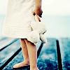 grey_gazania: a child in a white frock holding a teddy bear (they spend their lives on a rag doll)