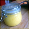 northern: Orange curd in a glass jar sitting on my wooden kitchen table. (cooking)