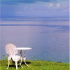 bermuda_jen: Wrought iron table and chair painted white, on a hill overlooking the sea around Bermuda. (Default)