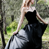 sound_ing: A woman with sandy hair, holding up the skirt of her gown so that it billows. Her face is out of frame. (gown)