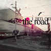 shirasade: a train passing by a crossing; text: "i am on the road" (travel - on the road)