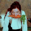 meloukhia: Lee from 'Secretary' kneeling on a desk with a carrot in her mouth, gazing seductively at the camera. (carrot)