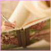 cytherea: A woman writes in a book with a pen. (NaNoWriMo)