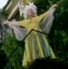 vass: Amanda Palmer in a long dress and white wig, on a balcony, gesturing with both arms up (Operatic)