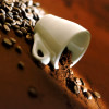 green_dreams: A tilted picture of a coffee cup spilling beans. (hang on to your cups)