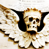 meloukhia: A winged death's head with a crown, carved in what looks like ivory (Skull)