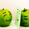 meloukhia: Two green apples, one with a happy face and one with a sad one. The sad one is propping up paper with a drawn happy face (Putting a face on it)