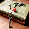 meloukhia: A skeleton key on a string of beads, laid out over a book (Key rosary)