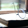 meloukhia: A pair of glasses lying on an open book (Resting glasses)