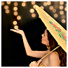 meloukhia: A person holding a parasol in the evening, reaching up as though to touch a strand of lights hanging in the air (Parasol by night)