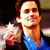 anoyo: Neal smiling and holding a Sheriff's badge. (wc neal badge)