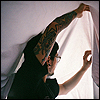 wake: Man lifting a sheet over his head, building a blanket fort. (Fort)