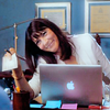 goodbyebird: Nurse Jackie: O'Hara is smiling from behind her laptop as she holds out a check. (NJ O’Hara)