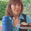 petra: A woman smiling with a thermos of tea and a plate of buns (Sarah Jane - Tea and buns)