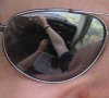 crazyscot: Close up of mirror shades, in which you can see the reflection of the photographer with one hand on the camera (flying eye)