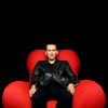 amihan: christopher eccleston as the ninth doctor in 'doctor who' seated on a red sofa, looking confused ([doctor who] nine (reality tv))