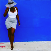 bilqis: black woman posing against a blue background with her grey hat worn down low (stock: hat down low stunt)