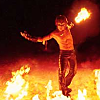 wintergrey: A bare chested young man dancing before a line of fire his right hand held above him is full of fire. (My muse dances with fire.)