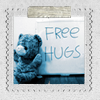 amadi: A teddy bear sits next to a sign advertising "Free hugs" (Free Hugs)
