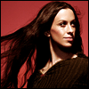 annaham: Photo of Alanis Morissette, standing against a red/pink wall with her hair flying behind her (Alanis [red wall]//annaham)