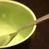 subluxate: Emptry green bowl with a spoon in it (Stock: Empty bowl)