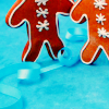 callie: two gingerbread peeps on a blue background, heads obscured (gingerbread)