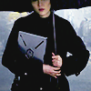 longwhitecoats: Mako Mori holding a file to her chest and raising an umbrella over her head (Mako)