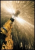 azurelunatic: A spray of $CELEBRATORY_FIZZY_BEVERAGE from a beribboned bottle caught in the moment just after the cork pops. (bubbly)