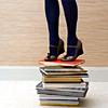 panda: photo of a woman standing on a stack of books (books: all the books?)