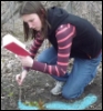 unfavorableinstigation: Nita Callahan kneeling in the woods, drawing a glowing blue diagram on the ground while reading from a book. (Drawing a Spell Diagram)